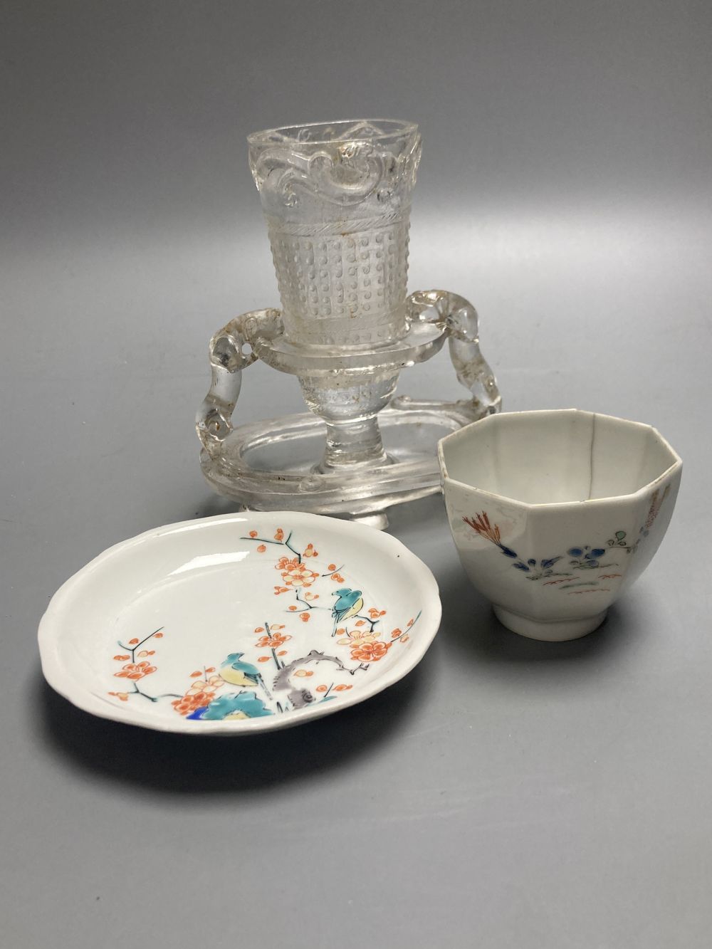 A Japanese Kakiemon dish, 17th century, a similar wine cup, 18th century and a Chinese glass vase and stand, tallest 14cm